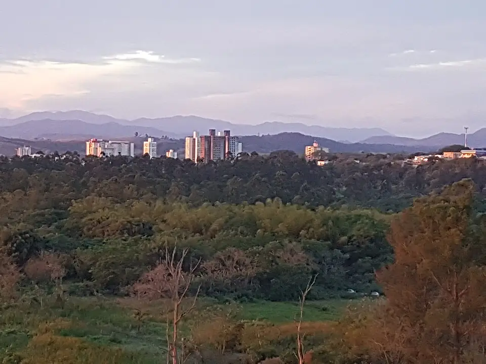 Banhado de São José dos Campos, com prédios da cidade e a Serra da Mantiqueira ao fundo